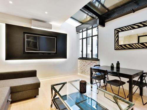 un salon avec une table en verre et un canapé dans l'établissement Blue Nights Apartments - Sébastopol, à Paris
