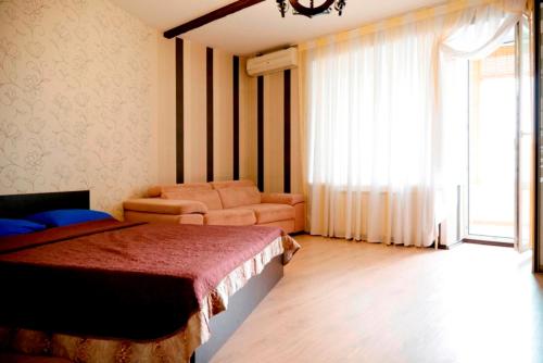 エカテリンブルクにあるАппартаменты на Щербаковаのベッドルーム1室(ベッド1台、ソファ、窓付)