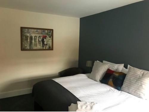 オックスフォードにあるBotley Townhouseのベッドルーム1室(ベッド1台付)が備わります。壁に絵が飾られています。