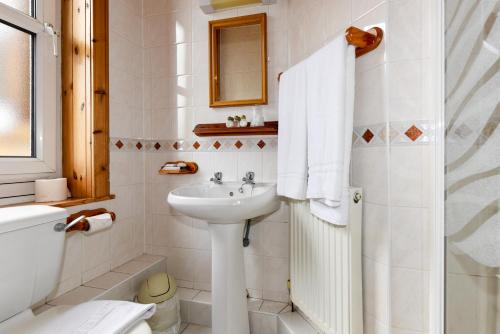 uma casa de banho branca com um lavatório e um WC em Brae Guest House em Edimburgo
