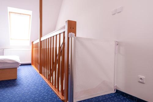 a room with a staircase and a bed and a window at Apartmány Engadin in Boží Dar