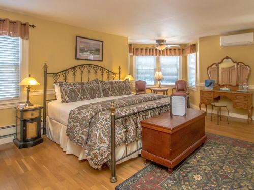 a bedroom with a bed and a table and a desk at The Bernerhof Inn in Bartlett