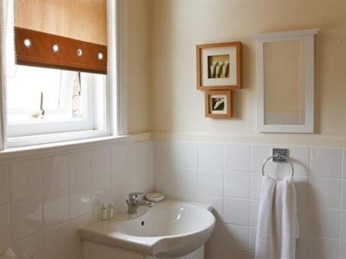baño blanco con lavabo y ventana en The Broadfield, en Bridlington