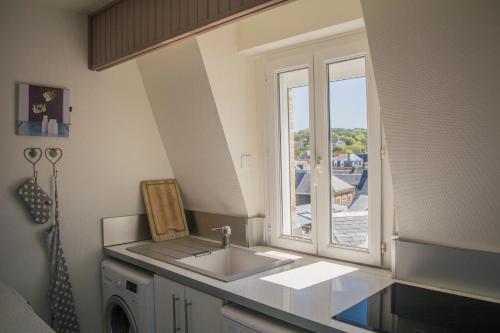 uma cozinha com um lavatório e uma janela em la belle vue le diamant des yeux mer et golf front mer em Étretat