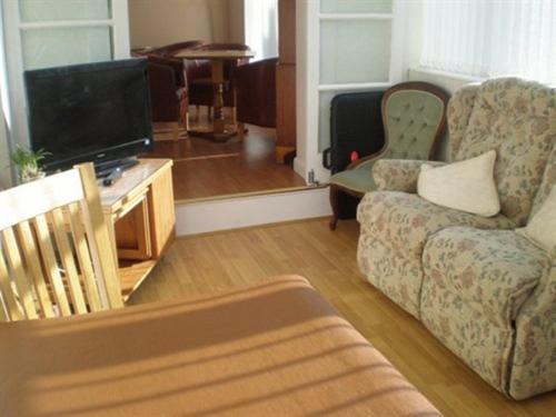 a living room with a couch and a tv at The Brockton in Bridlington