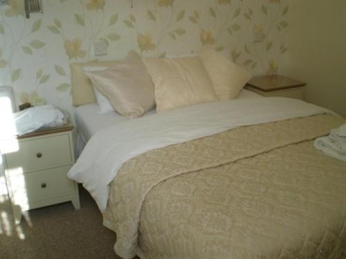 a bedroom with a bed and a night stand with a lamp at The Brockton in Bridlington