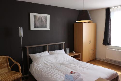 a bedroom with a white bed and a chair at Brussels BnB in Brussels