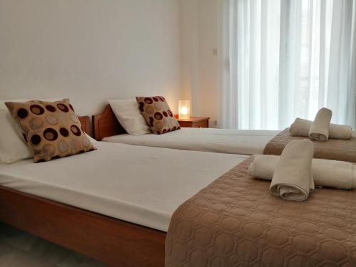 - 2 lits dans une chambre aux murs blancs dans l'établissement Villa Alexandra Ierissos, à Ierissos
