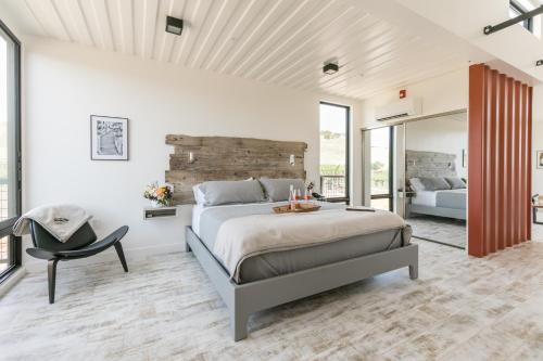 a bedroom with a large bed and a chair at Geneseo Inn in Paso Robles