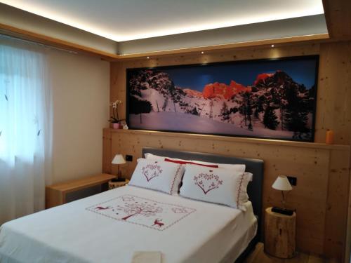 a bedroom with a bed with a tv on the wall at B&B DeBy & E-Bike Rental in San Nicolò di Comelico