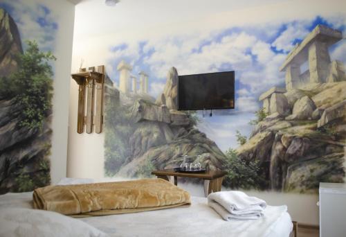 a bedroom with a mountain mural on the wall at Pensiunea Hubertus in Bistriţa