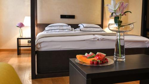 a bedroom with a bed with a table with a plate of fruit at Heritage Hotel Kukuriku in Kastav