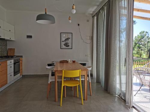 Una cocina con una mesa de madera y sillas amarillas. en Shekvetili Vacation Home, en Shekhvetili