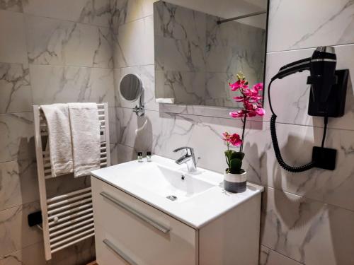a bathroom with a sink and a phone on the wall at Hôtel Casa Mea in Bastia