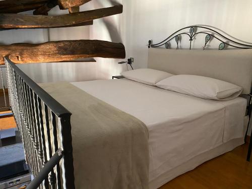 a bedroom with a white bed with a metal headboard at Serendipity Quando l'Amore è Magia in Bergamo
