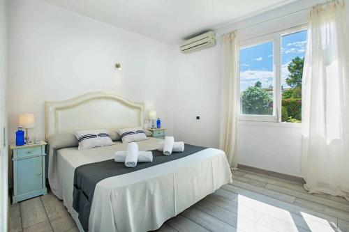 Un dormitorio blanco con una cama con toallas. en Beach Villa Can Ros, en Puerto Pollensa