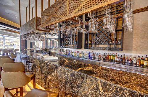 a bar with a counter with bottles of alcohol at Royalton Bavaro, An Autograph Collection All-Inclusive Resort & Casino in Punta Cana