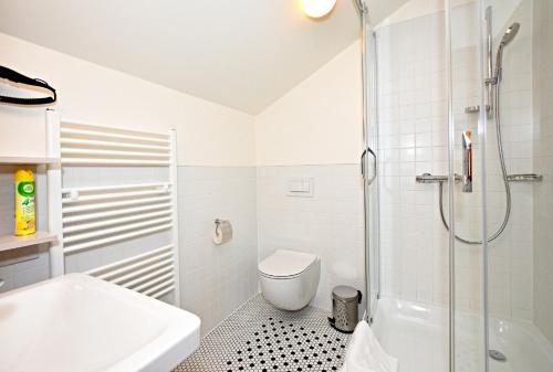 a bathroom with a shower and a toilet and a sink at Pivovar Řevnice in Řevnice