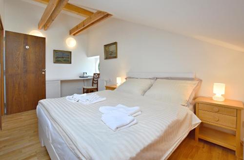een slaapkamer met een wit bed en 2 handdoeken bij Pivovar Řevnice in Řevnice