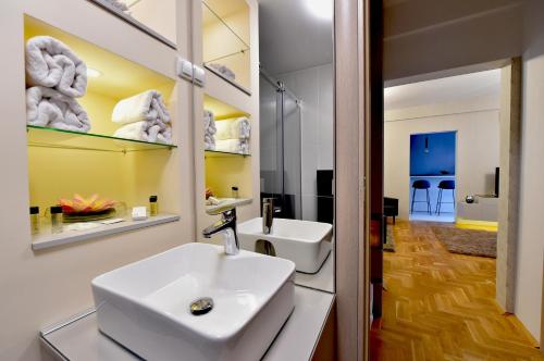 a bathroom with a white sink and a mirror at Sky lux apartman in Gornji Milanovac
