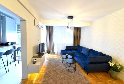 a living room with a blue couch and a television at Sky lux apartman in Gornji Milanovac