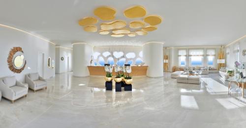 a large living room with white furniture and a ceiling at Anax Resort and Spa in Agios Ioannis Mykonos