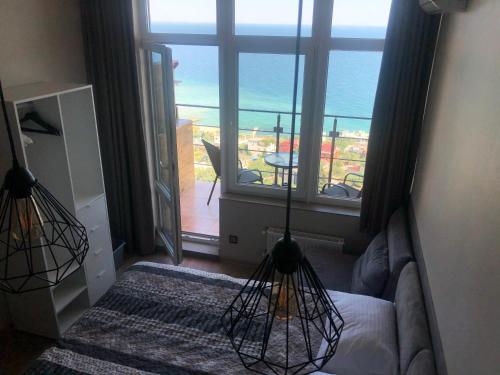 a bedroom with a large window with a view of the ocean at Panorama 44 in Odesa