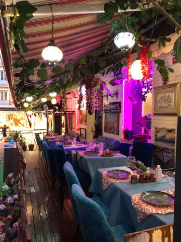 una fila de mesas en una habitación con iluminación púrpura en Adora Hotel Cafe & Restaurant en Estambul