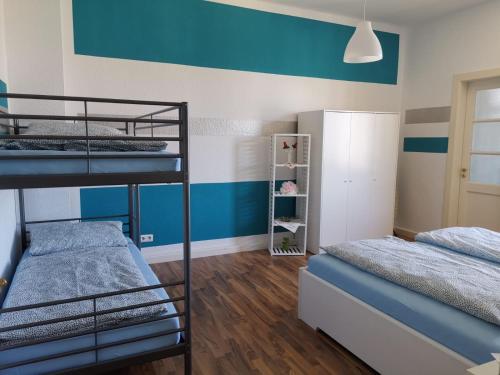 2 Etagenbetten in einem Zimmer mit blauen und weißen Wänden in der Unterkunft Ferienwohnung Harmonie 45 m2 in Solingen
