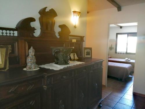 Habitación con un gran tocador de madera en un dormitorio. en La pension del Parador, en Galisteo