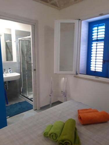 um quarto com uma cama com toalhas verdes em Il Cortiletto su levanzo em Favignana