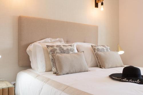 a white bed with pillows and a hat on it at beachome4u2 in Carcavelos
