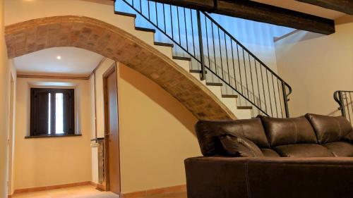 a living room with a couch and a staircase at Pujolís in Santa Cecilia de Voltregá