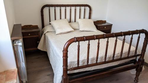 1 dormitorio con 1 cama de madera y 2 mesitas de noche en Pujolís, en Santa Cecilia de Voltregá