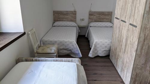 a room with two beds and a chair at Pujolís in Santa Cecilia de Voltregá