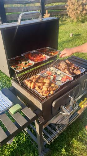 a person is cooking food on a grill at Malowniczy Zakątek w Dercu in Derc
