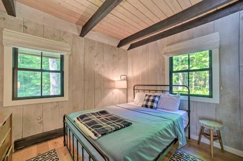 a bedroom with a bed and two windows at Sleek Cabin with Deck, 8 Miles to Mount Snow and Hikes in Wilmington