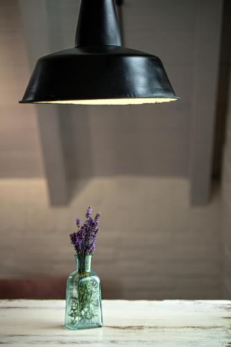 a black lamp and a glass vase with purple flowers at Bieszczadzka Stodoła in Ustrzyki Dolne