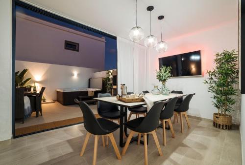 a dining room and living room with a table and chairs at Villa palmera jacuzzi in Yaiza