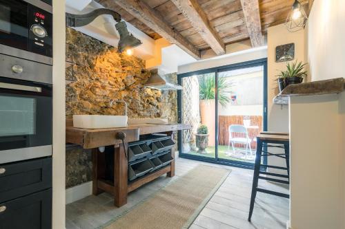 eine Küche mit einer Theke und einer Steinmauer in der Unterkunft Les Deux Clefs in Mont-de-Marsan