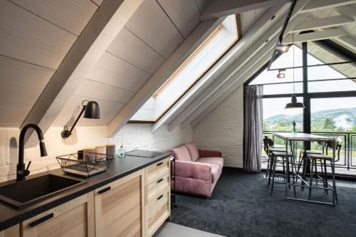 a kitchen and living room with a couch and a table at Bieszczadzka Stodoła in Ustrzyki Dolne