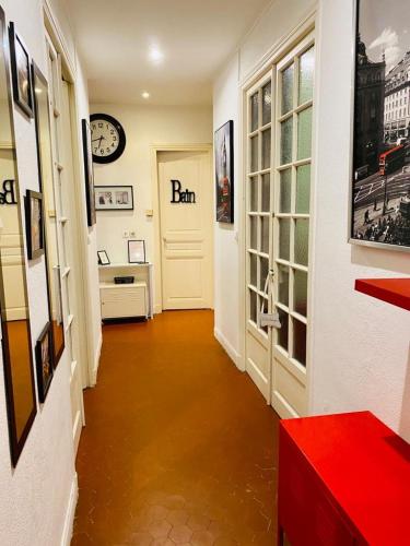 un couloir avec une porte et une horloge sur le mur dans l'établissement Appartement Hyper Centre Ville, à Menton