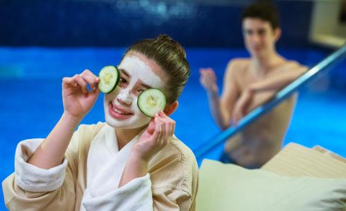 a woman with cucumbers on her face and a man at Royalton Bavaro, An Autograph Collection All-Inclusive Resort & Casino in Punta Cana
