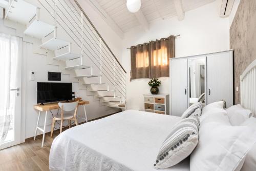 biała sypialnia z dużym łóżkiem i schodami w obiekcie Ca' Mira - Room&Breakfast w mieście Savio di Ravenna