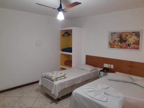 Pokój z 2 łóżkami i wentylatorem sufitowym w obiekcie Psiu Lanches e Hotel Veraneio w mieście Posse