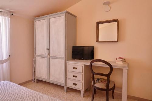 a bedroom with a desk with a television and a cabinet at CORE MIO in Assisi