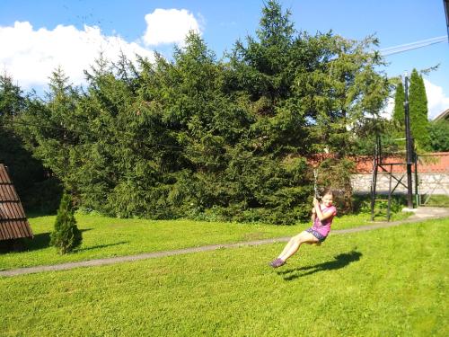 a young girl is playing with a kite in a field at Cozy family house in Odorín