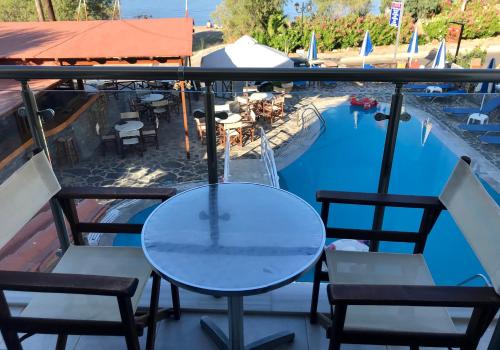 a table and chairs on a balcony with a swimming pool at Lena Apartments in Elounda