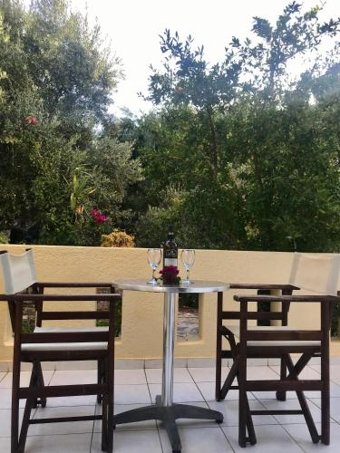 a table and chairs with wine glasses on a patio at Lena Apartments in Elounda