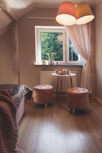 a bedroom with a bed and a table and a window at Apartamenty Willove Wzgórze in Duszniki Zdrój